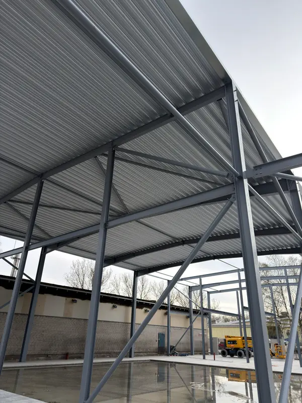 First profiled roof-deck sections installed over the existing steel frame