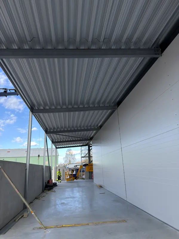 Installed roof deck and white wall panels forming a covered service bay