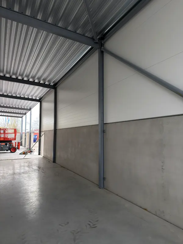 Clean interior sandwich-panel wall beneath the installed roof deck