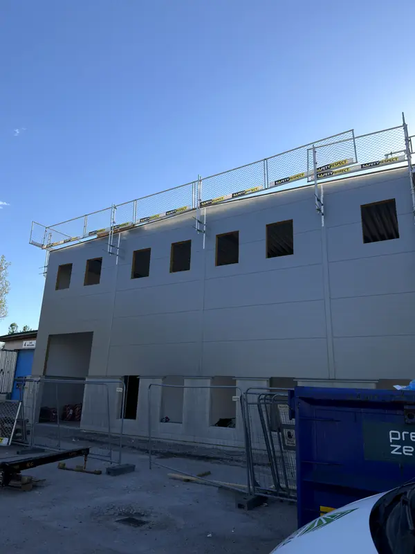 Completed second façade elevation clad in grey sandwich panels