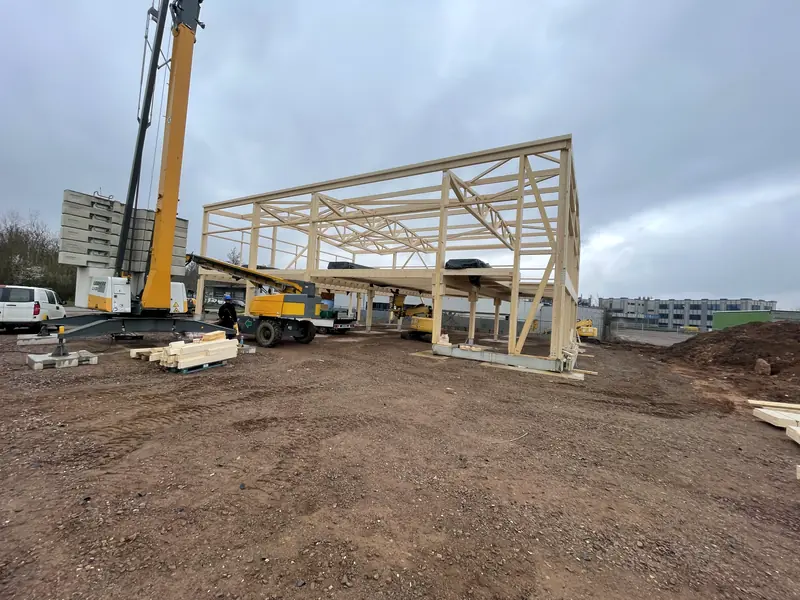 Timber roof truss being lifted onto the steel structure