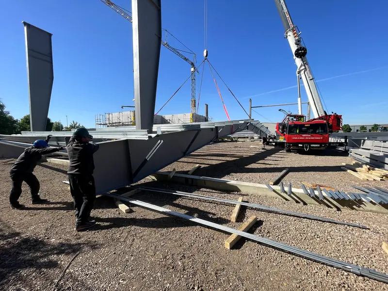 Installation crew guiding a steel column into position on site